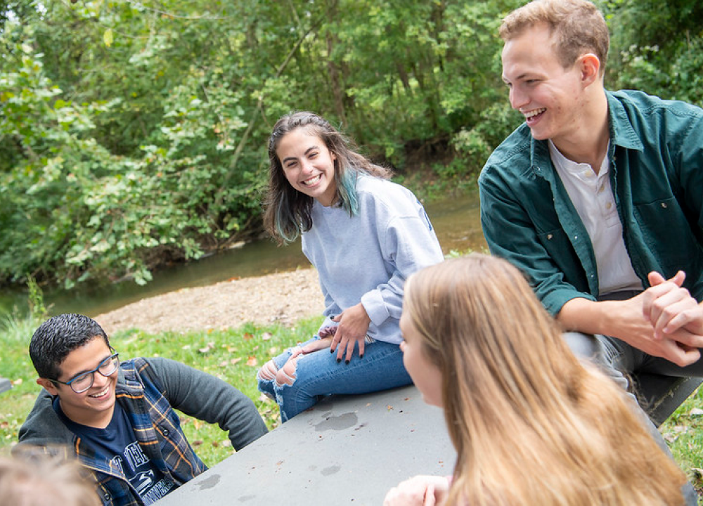 A group of students sitting at a table outside