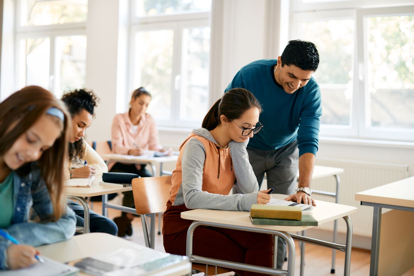 female-high-school-student-leaning-with-teacher-s-2022-11-23-18-00-59-utc