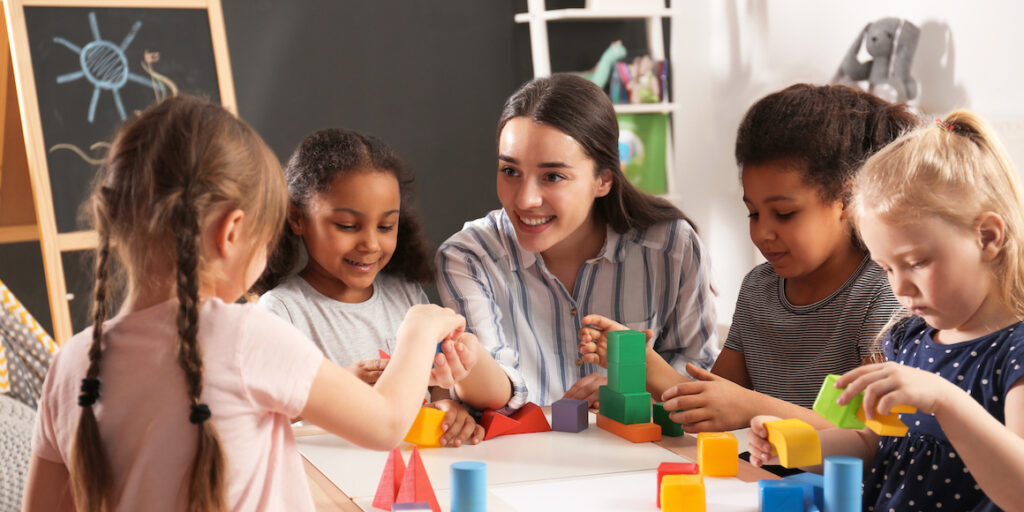 Ohio elementary school teacher showing students how to build fun structures using colorful building blocks