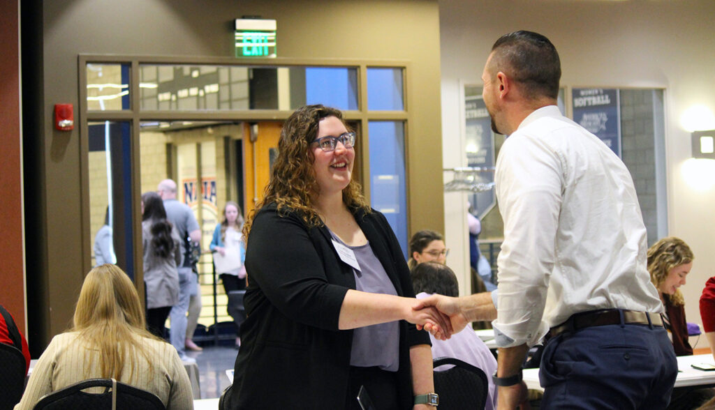 MVNU student shakes hands with school district representative during Career Interview Fair