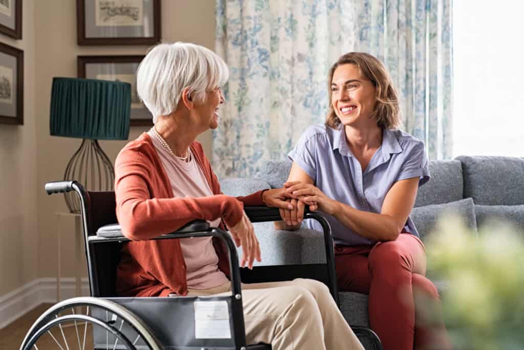 Social worker helping older woman in wheelchair.