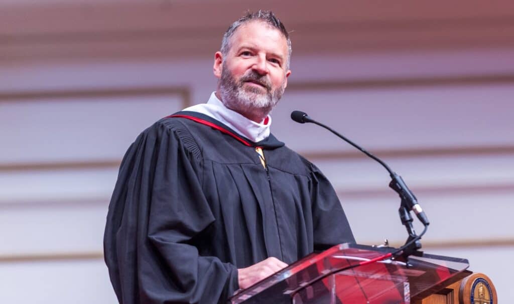 Man stands at podium and speaks