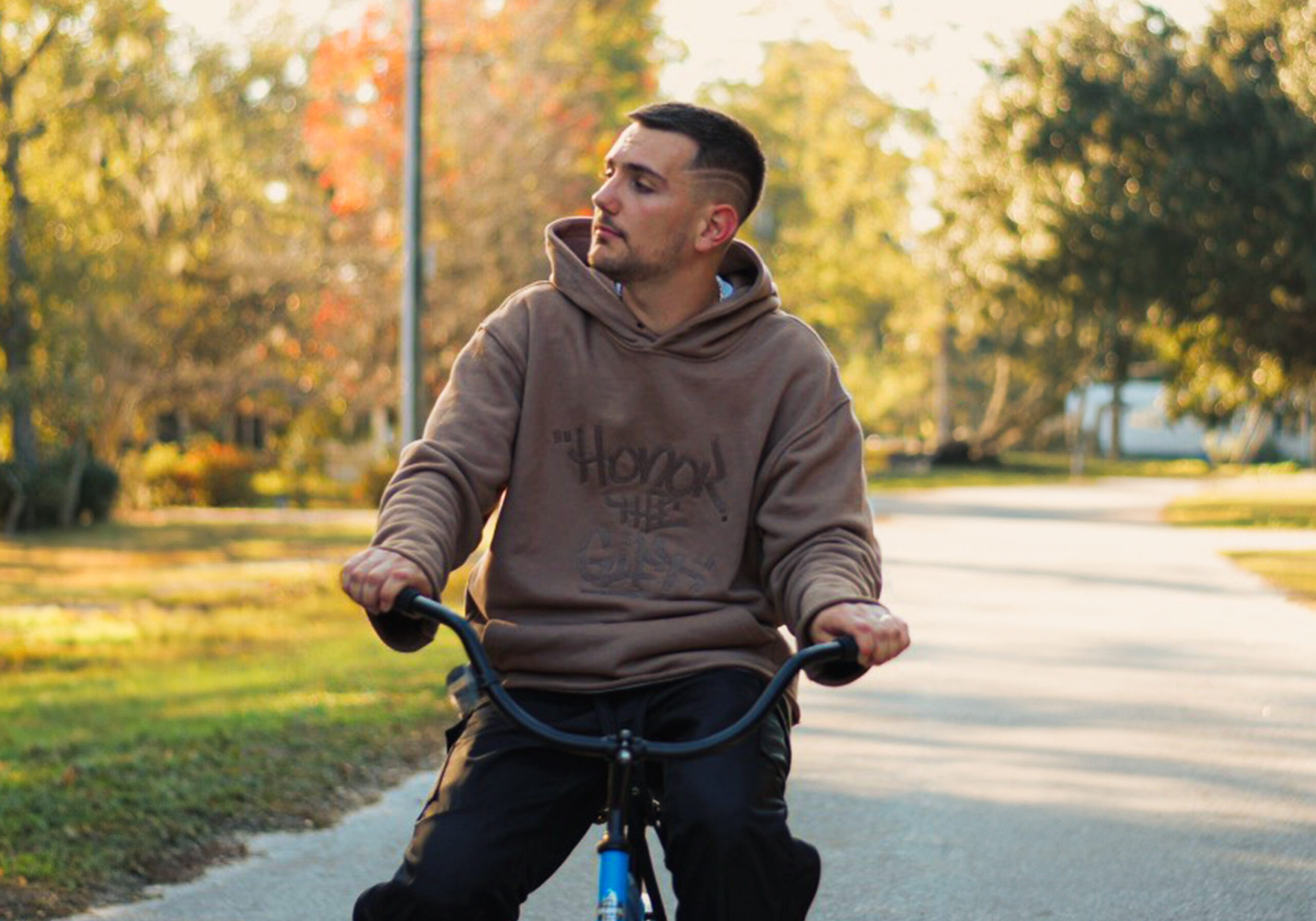 HULVEY riding a bicycle down a street.