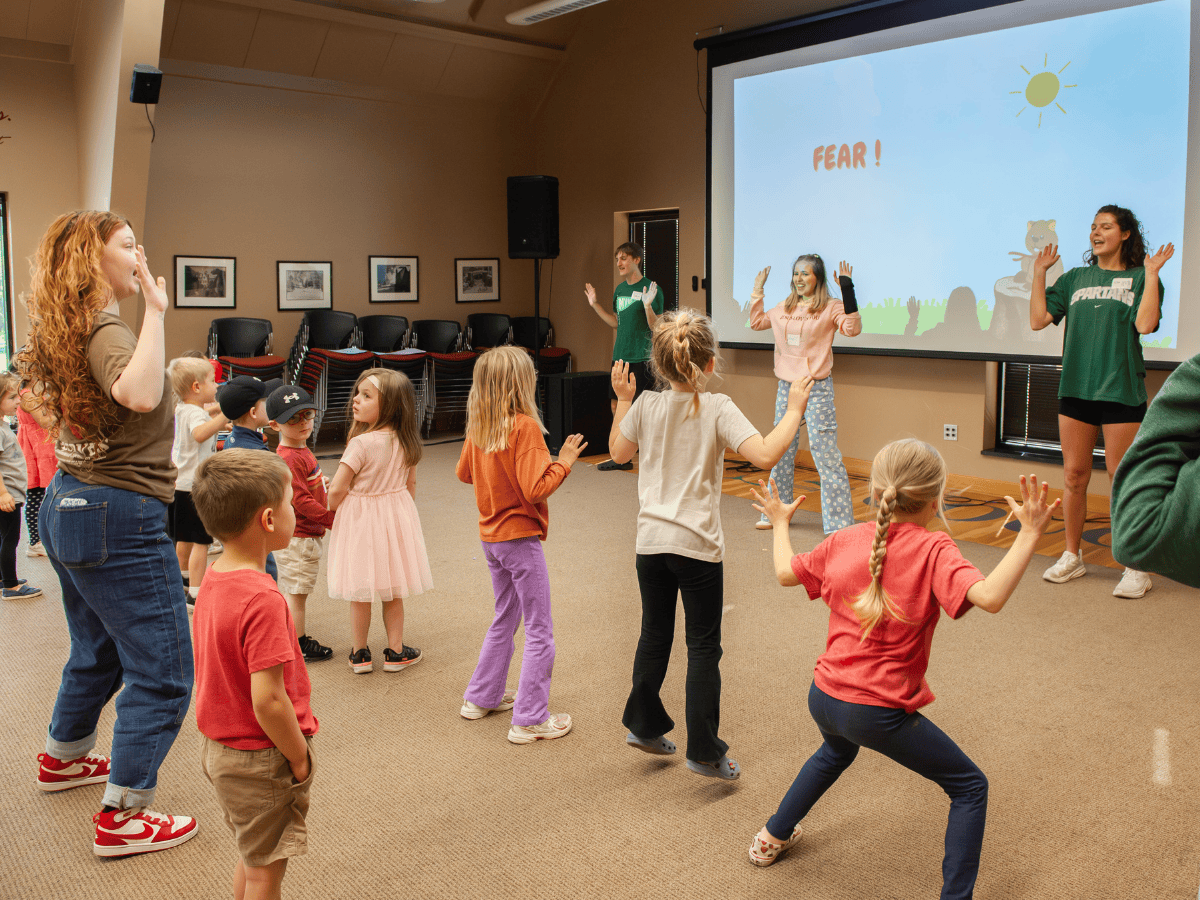 Children participating in a pastoral ministry event with kids dancing and singing.