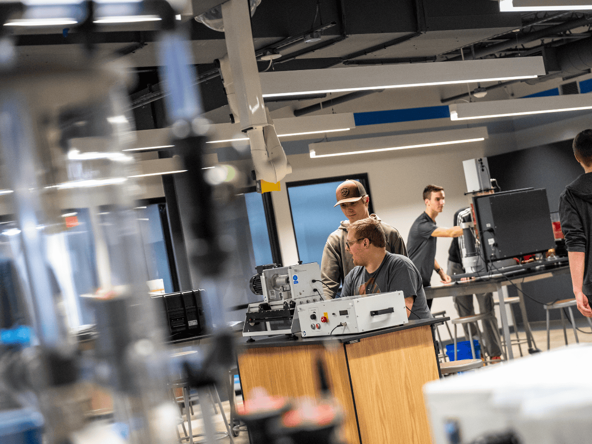 Students working on electronic circuit projects in a modern laboratory setting.