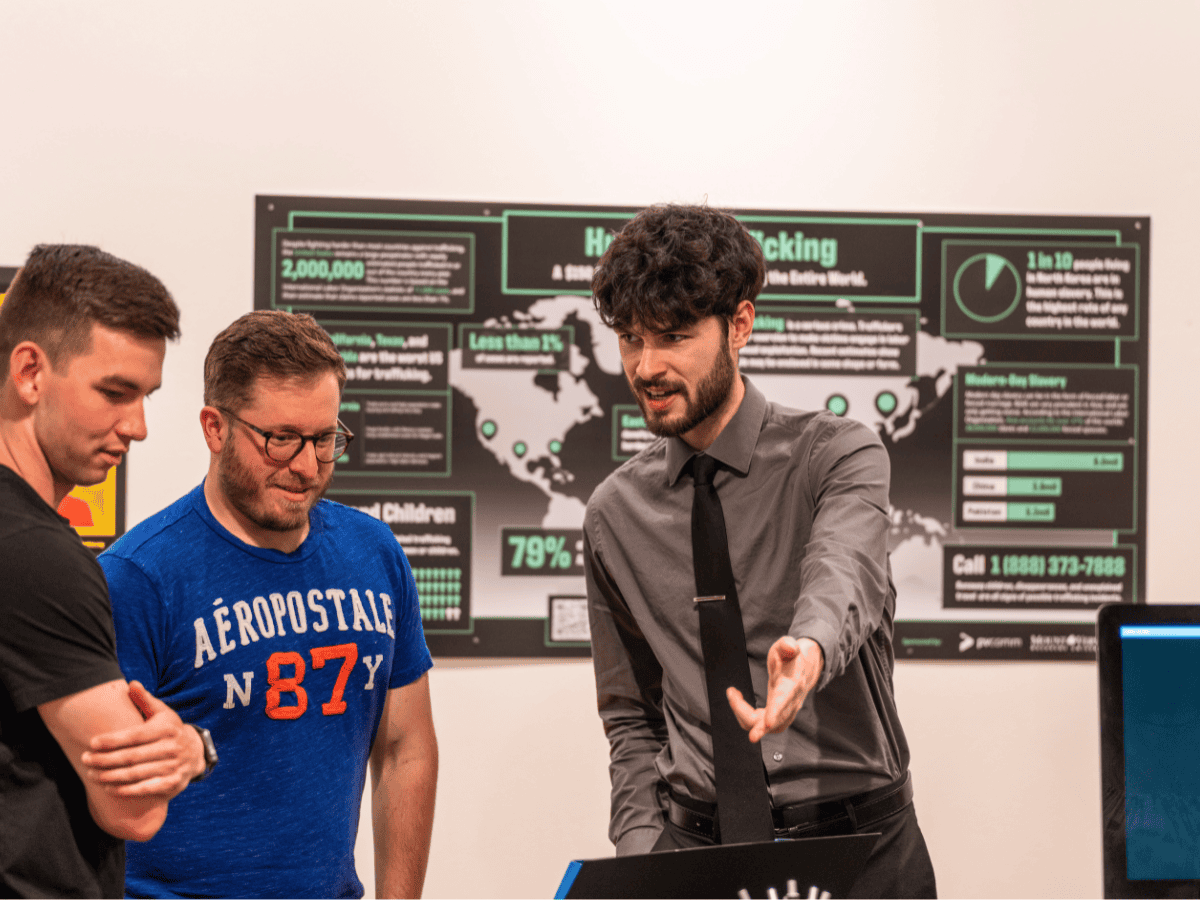 Cybersecurity presentation with three men discussing data security and hacking prevention.