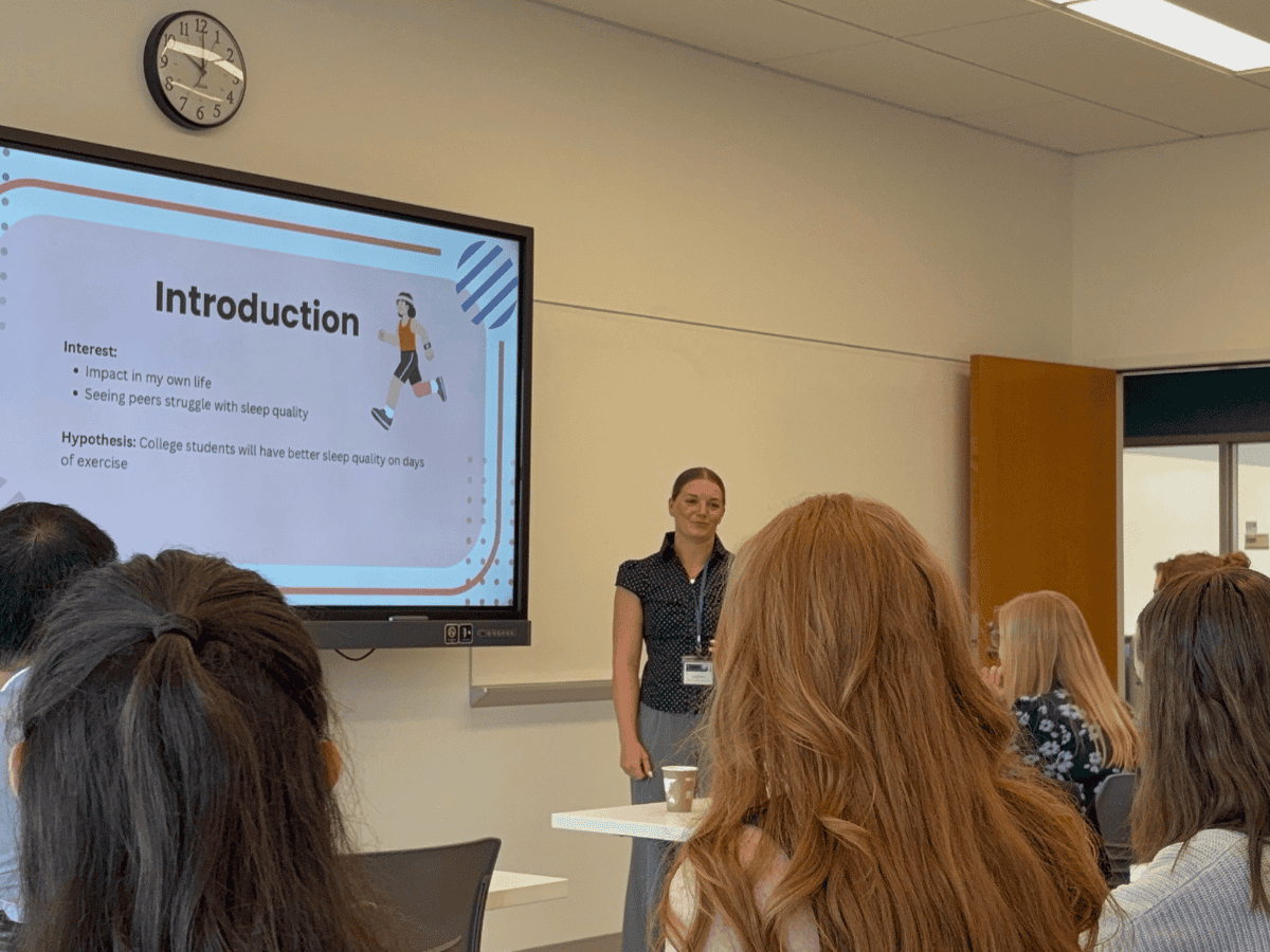 "Presenter explaining a slide titled 'Introduction' to a classroom audience.".