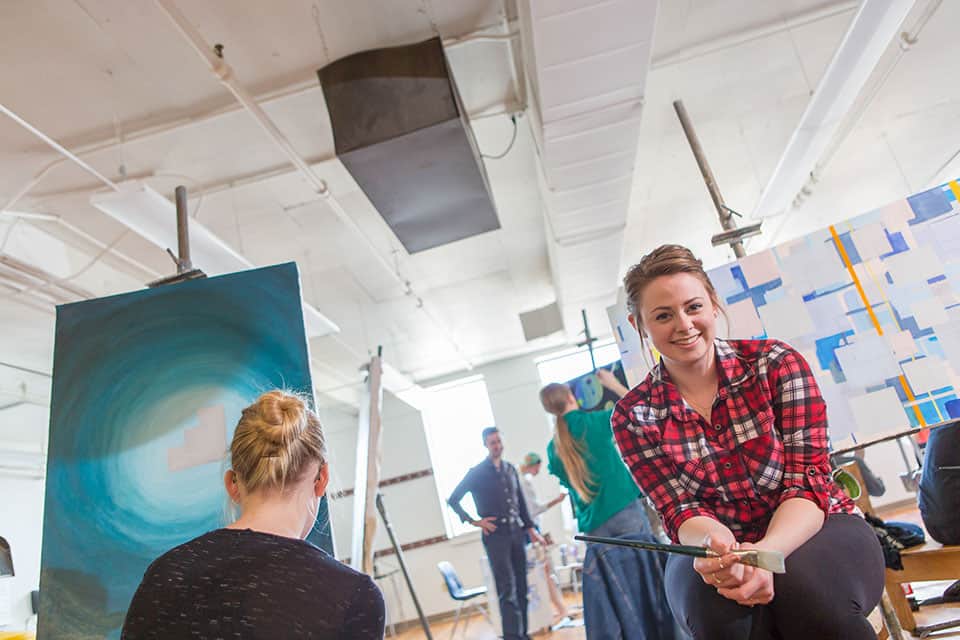 A vibrant art gallery with people engaging in painting activities.