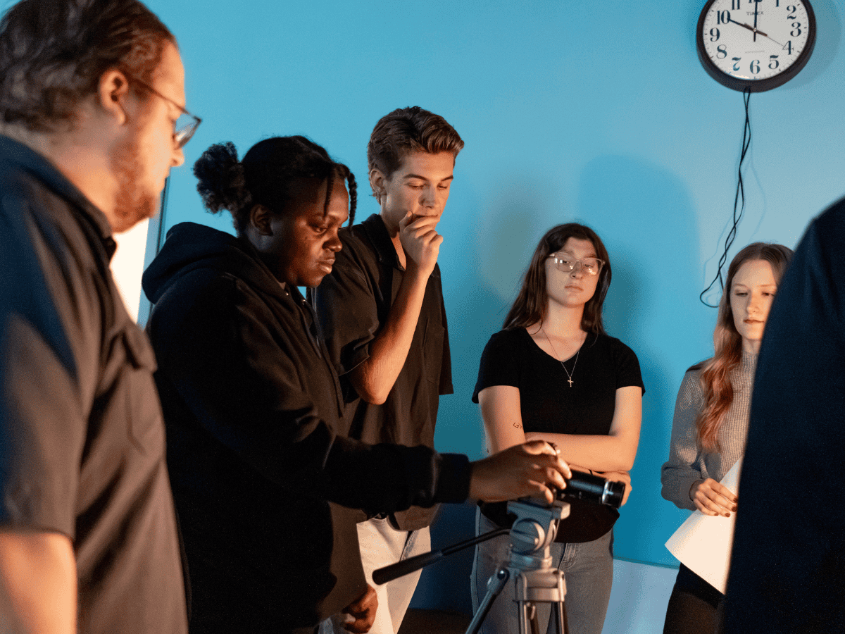 Group of young people in a media workshop with camera equipment.