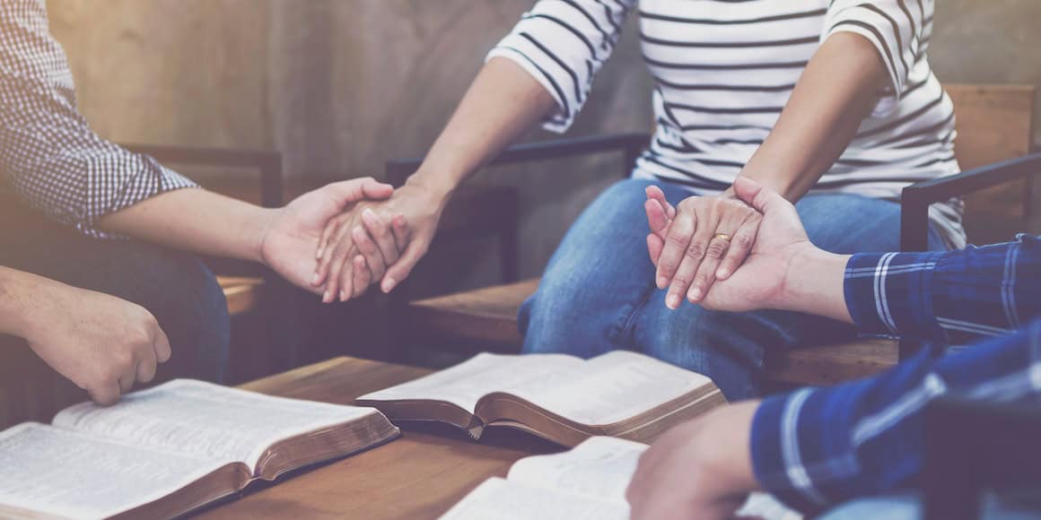 Holding hands in a support group meeting for emotional healing and community support.