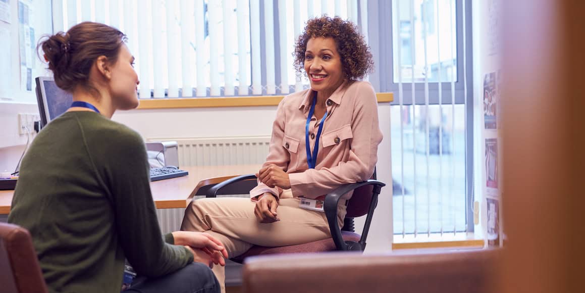 Friendly businesswoman and interviewer having a conversation in an office setting.