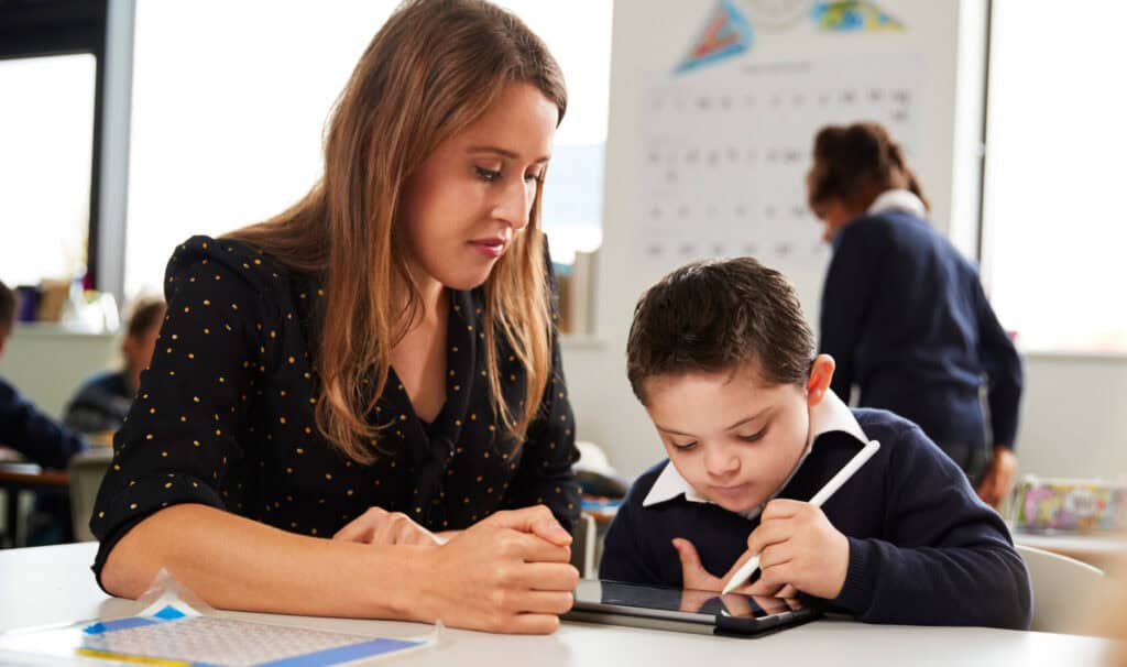 A teacher works one-on-one with a young student using a tablet in the classroom. At MVNU, online education programs prepare future intervention specialists to provide individualized support that helps every child succeed.