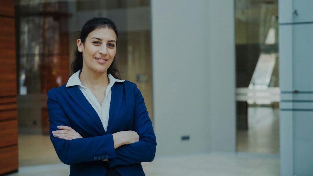 Professional woman standing confidently in a modern workplace, representing leadership growth for working adults in Cleveland