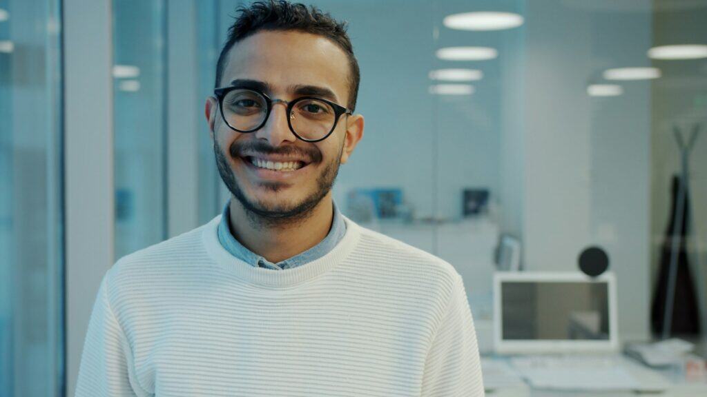 Smiling professional in a modern office setting, representing compassionate leadership development for working adults in Cincinnati