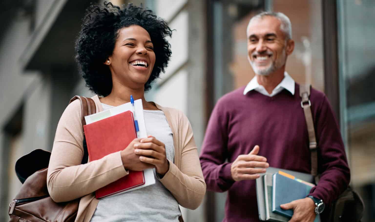 Smiling adult learners walking with books on campus, representing working professionals pursuing flexible, supportive online degree programs through MVNU Online.