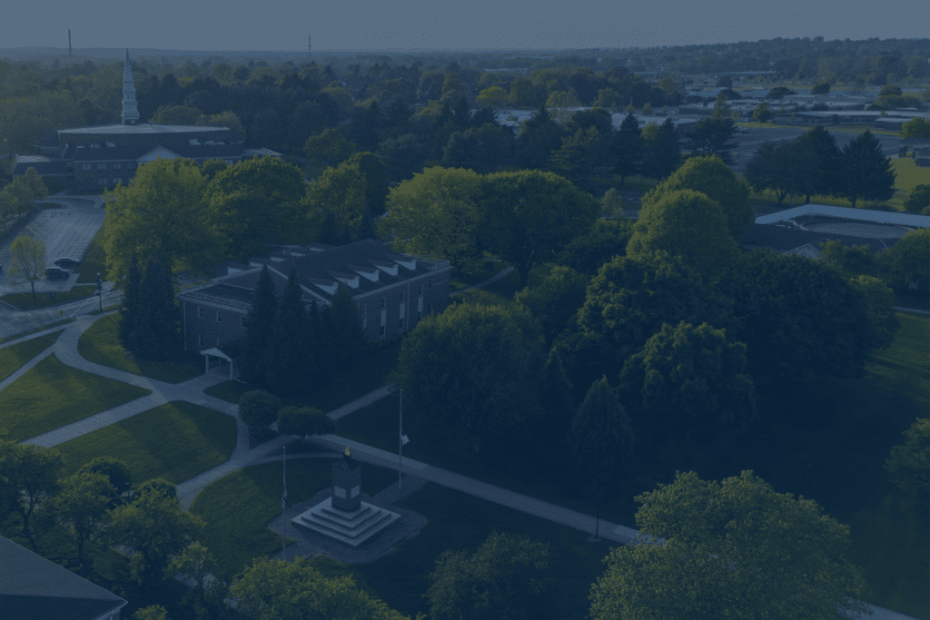Aerial view of a park with trees and pathways in a city setting.