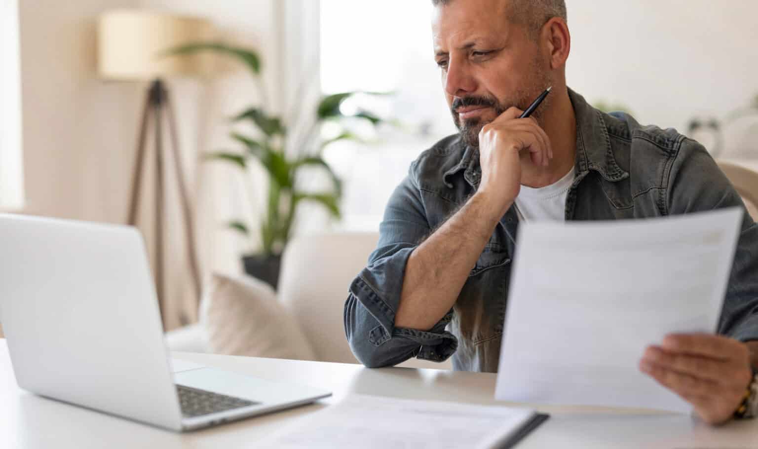 A man reviewing documents at his desk, reflecting the careful research working adults do before choosing an online degree program at MVNU.