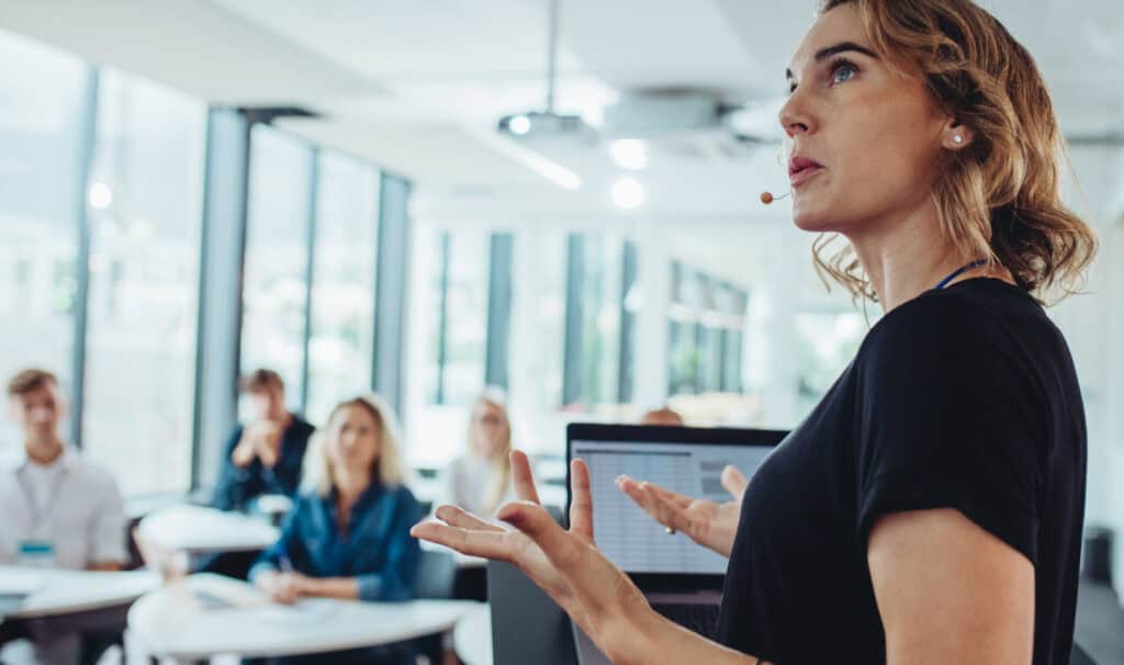 Professional woman presenting strategy to a team in a modern office setting, representing leadership development through MVNU Online graduate programs in business and management.