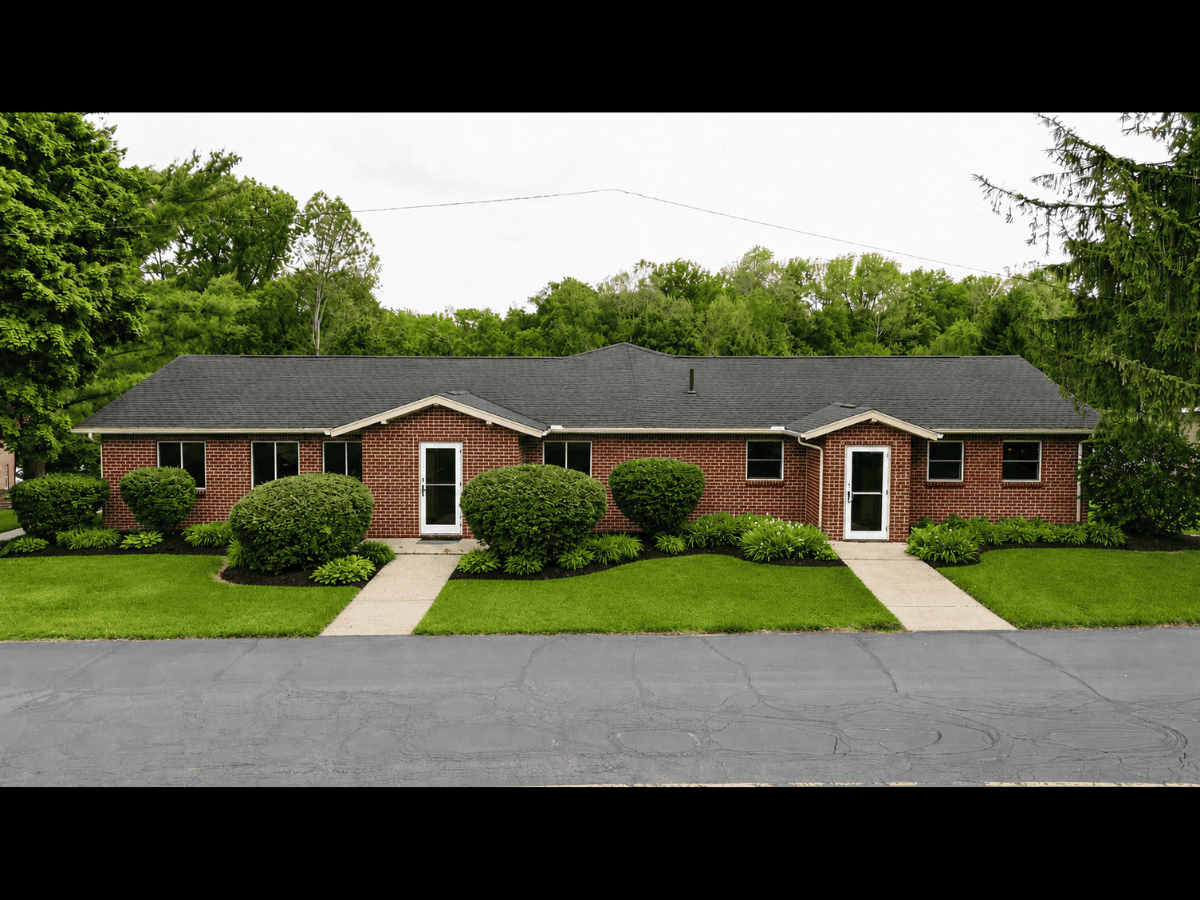 Brick duplex with well-maintained lawn and shrubs in The Bridges Center area.
