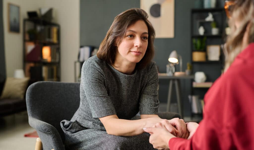 A social worker offering reassurance to a client during a one-on-one conversation in a warm office setting, representing the compassionate practice taught in MVNU Online's social work programs.
