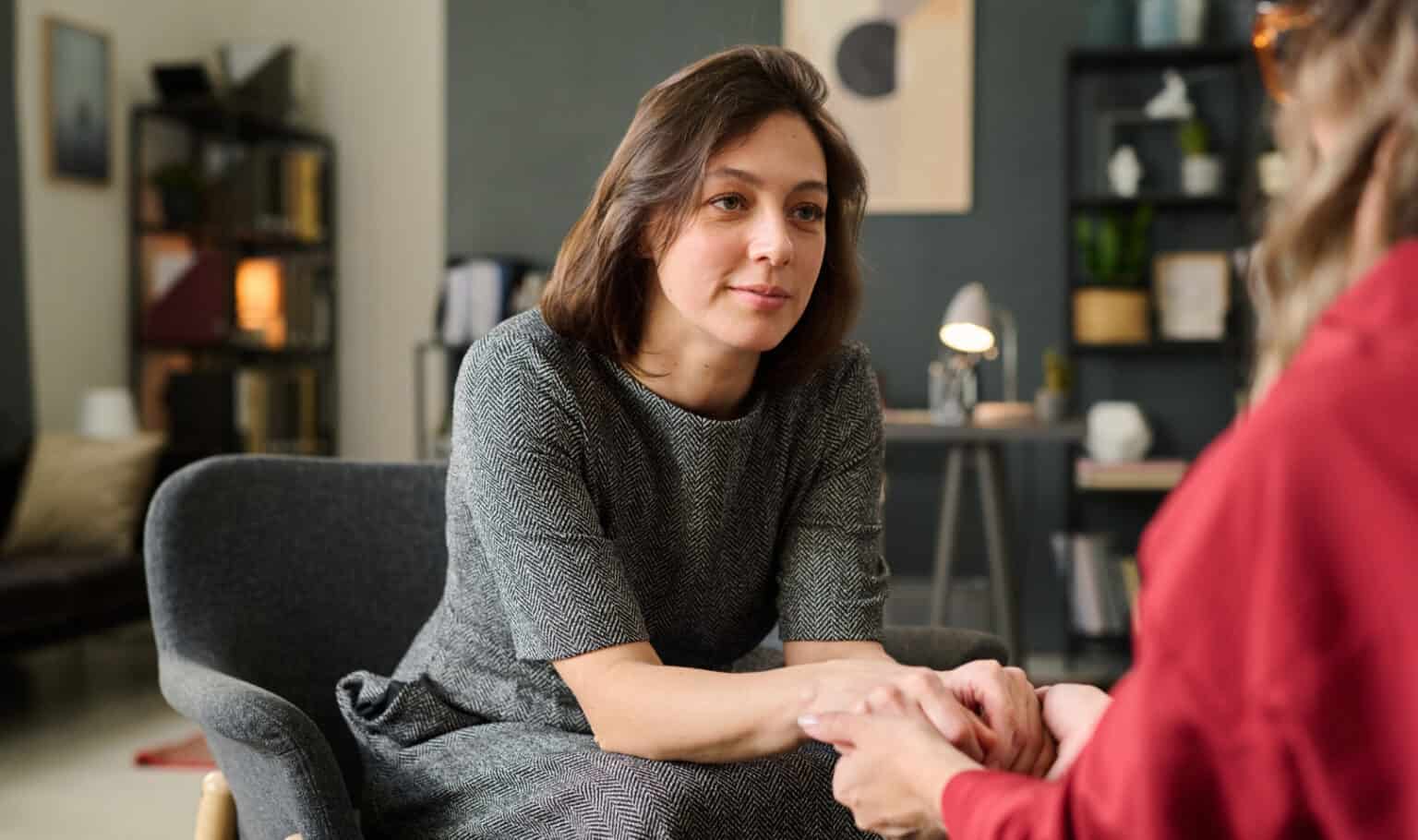 A social worker offering reassurance to a client during a one-on-one conversation in a warm office setting, representing the compassionate practice taught in MVNU Online's social work programs.