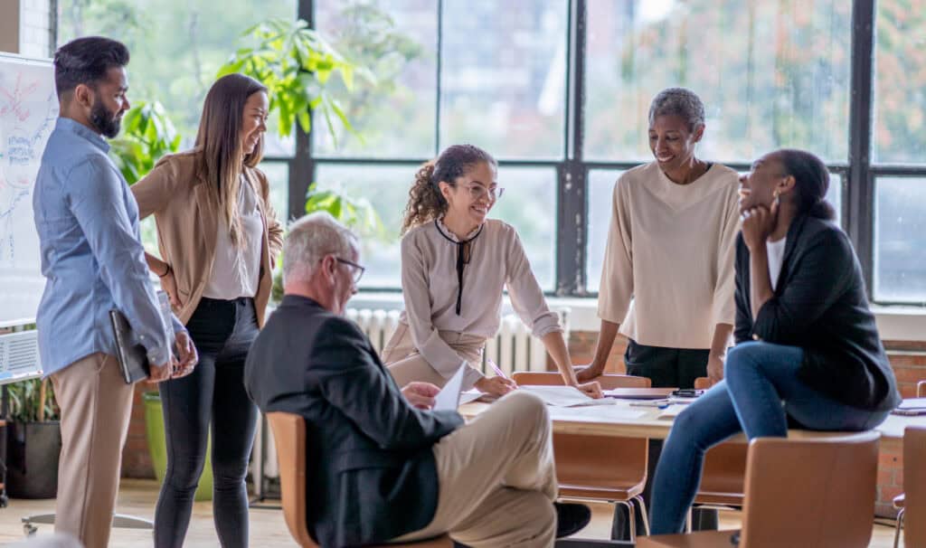 A diverse group of professionals collaborating around a table, reflecting the leadership growth an MBA, MSM, MOL, or Master of Ministry can provide.