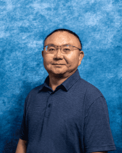 Portrait of Dr. Minfeng Li in a blue shirt against a blue background.