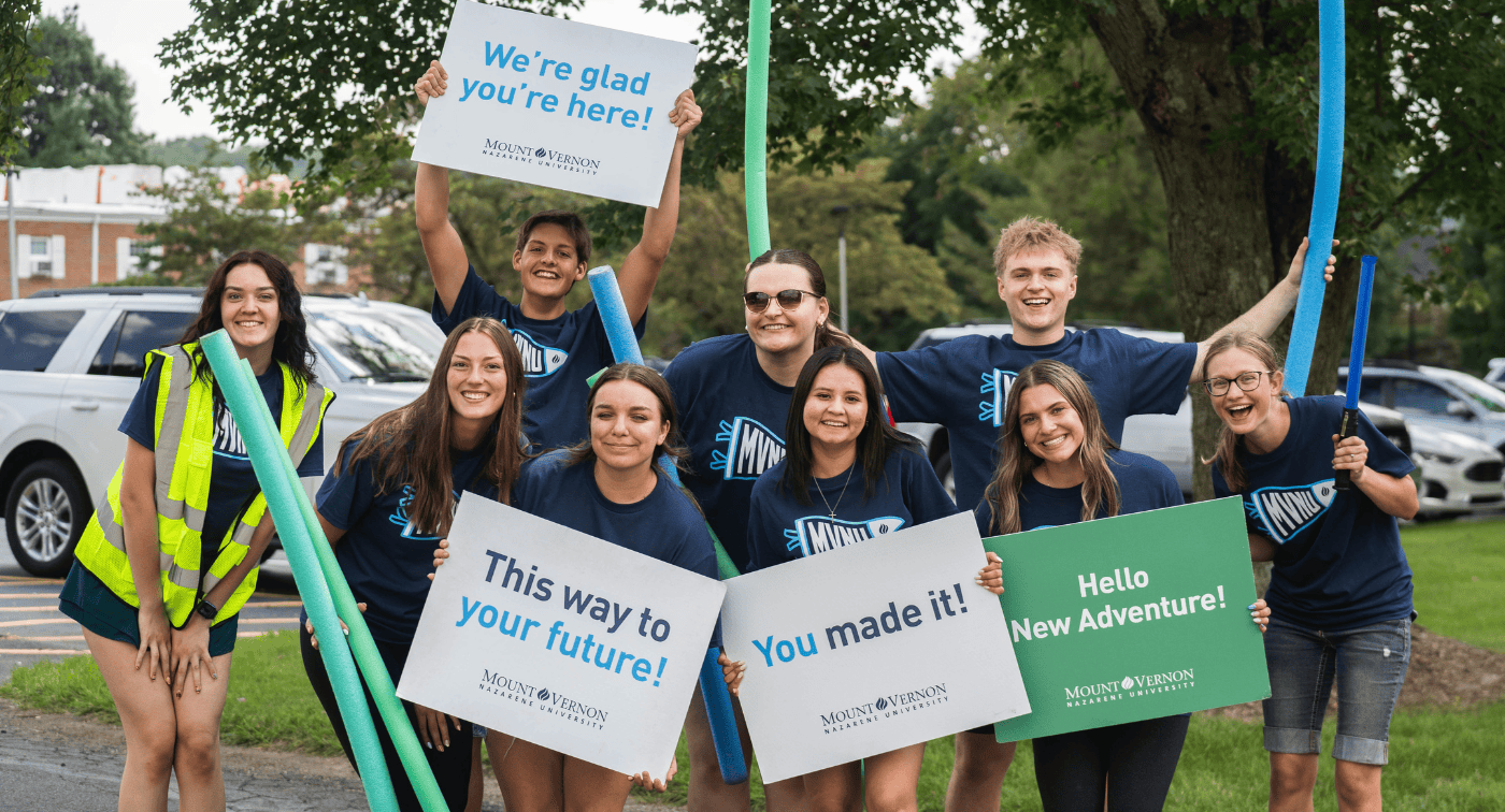 Group of MVNU students holding signs smiling and celebrating move-in day.