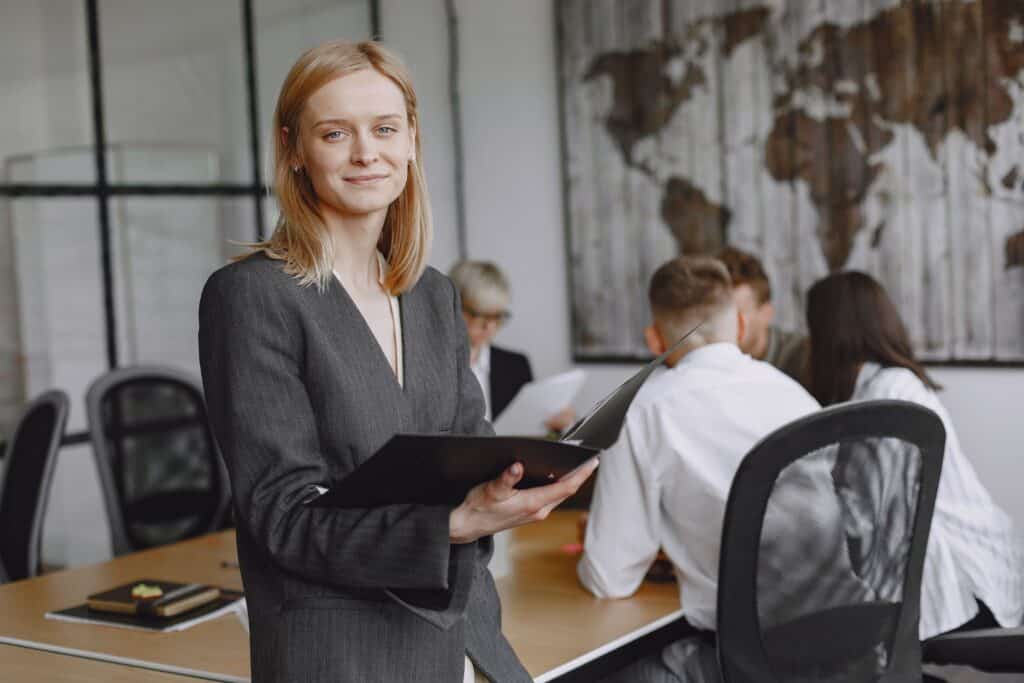Businesswoman holding a folder in a conference room, representing Cleveland professionals pursuing MVNU’s online Master of Organizational Leadership.