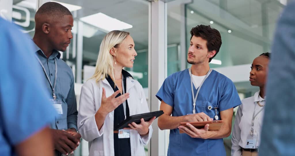 Nurse leader speaking with a healthcare team during a clinical planning meeting
