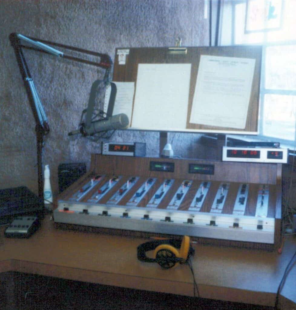 Radio station studio with microphone, soundboard, and headphones.