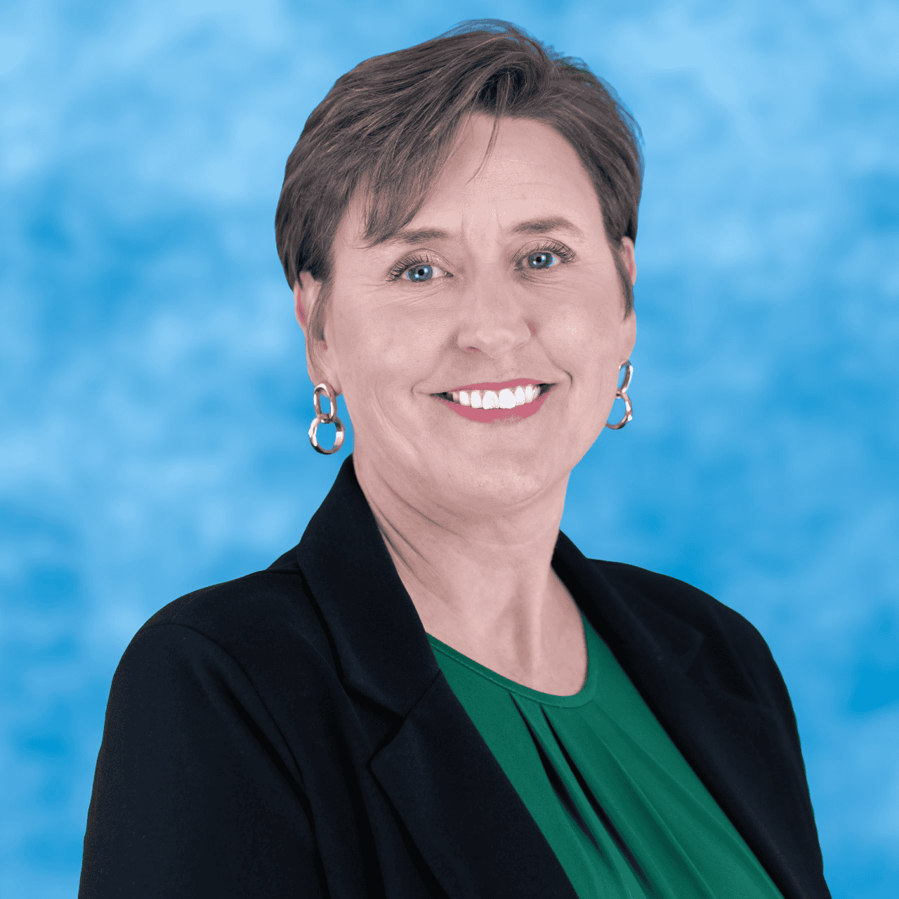 A woman smiling in professional attire against a blue background.