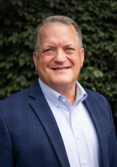 Smiling male speaker in a blue suit at the conference.