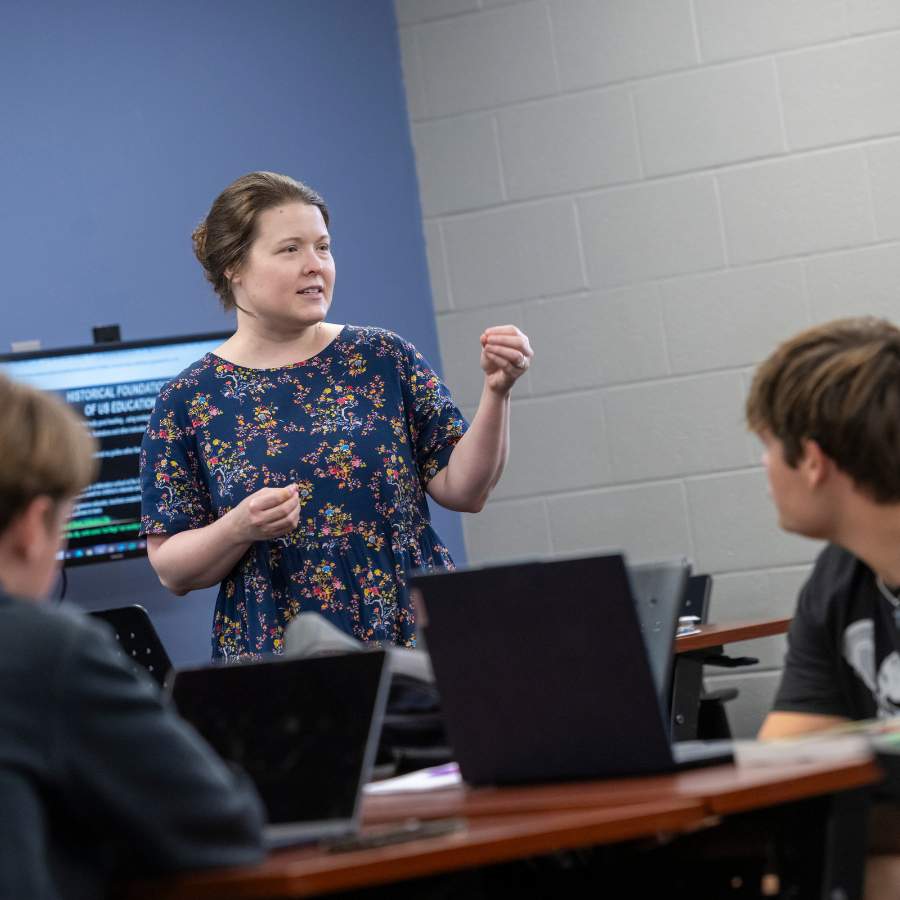 Teacher leading a discussion with students in a classroom setting.